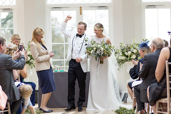A Groom celebrates after his wedding at Rockbeare Manor