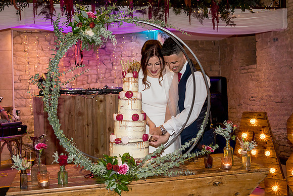 Bride and Groom cut their cake at the Great Tythe Barn in Tetbury
