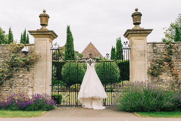 Wedding dress hanging on the gates at Lucknam Park in Wiltshire