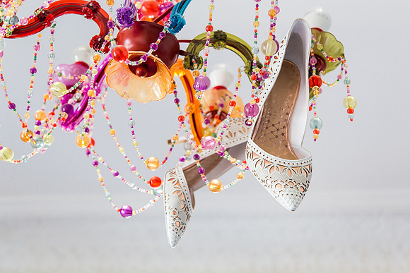 Bridal shoes hanging in chandelier